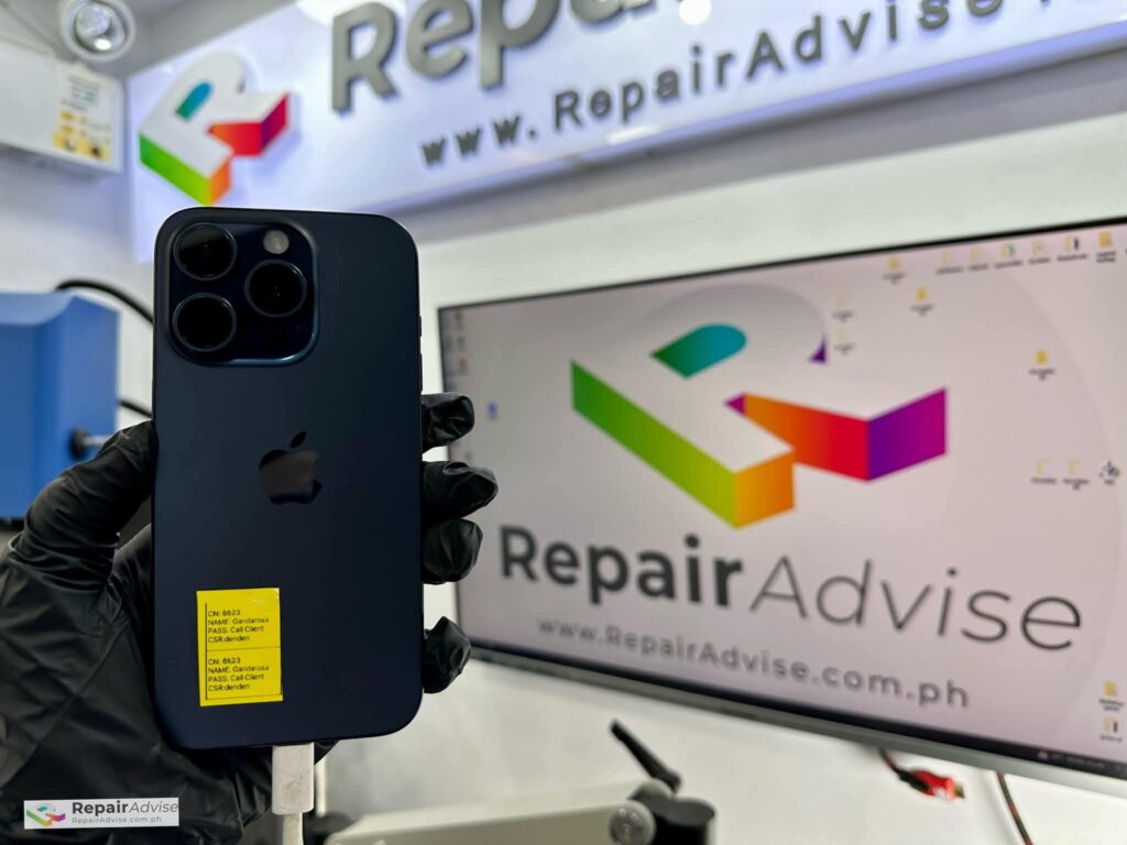 iPhone 15 with back glass removed, exposing internal components under repair